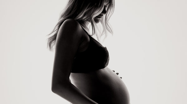 Profielfoto van een zwangere vrouw in haar ondergoed. ©Janko Ferlic voor Unsplash.